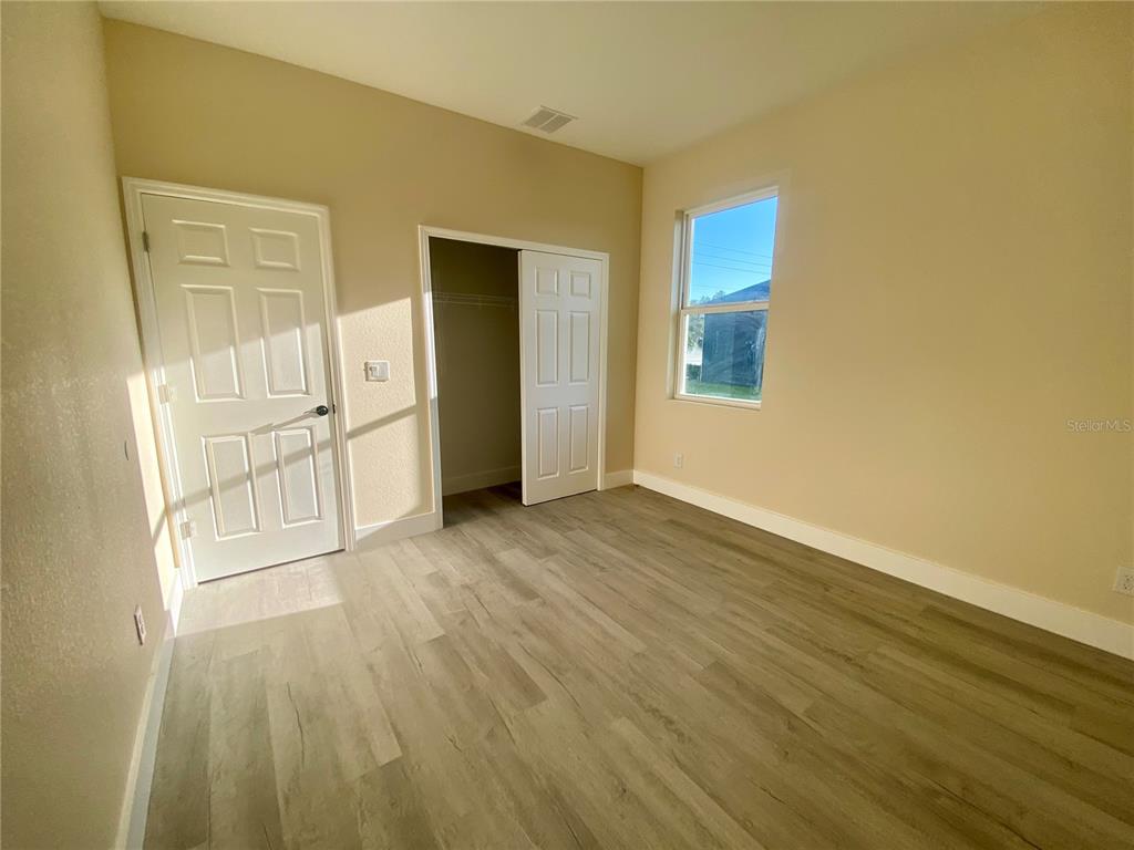4449 Schumacher Road Sebring, FL 33872 - Photo 24 of 32 a view of empty room with wooden floor and entryway
