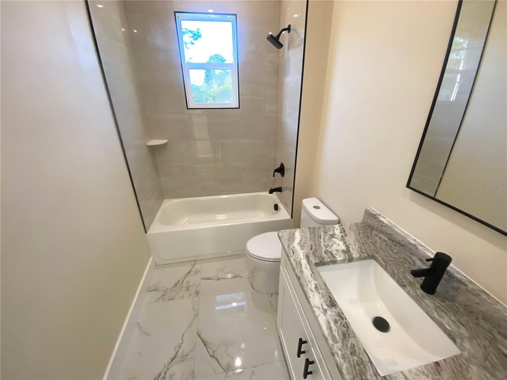 4449 Schumacher Road Sebring, FL 33872 - Photo 25 of 32 a bathroom with a granite countertop sink toilet and shower