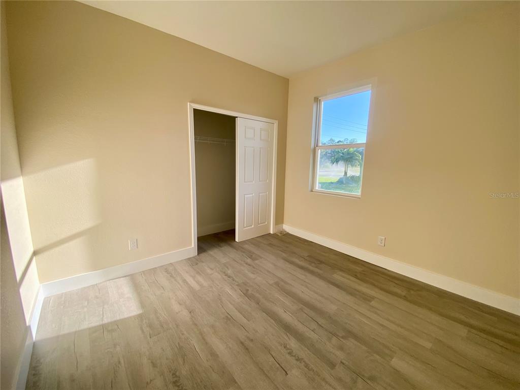 4449 Schumacher Road Sebring, FL 33872 - Photo 27 of 32 a view of an empty room with wooden floor and a window