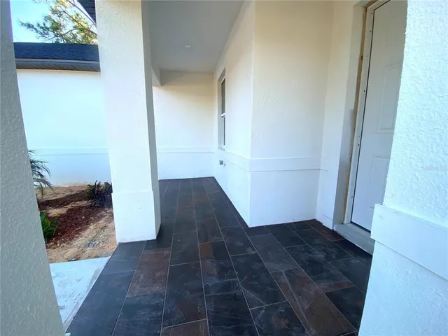 a view of a hallway with wooden floor and a bathroom