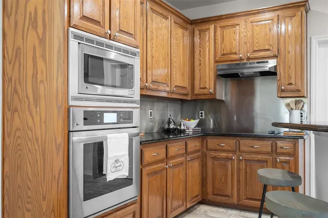 a kitchen with stainless steel appliances granite countertop a stove and cabinets