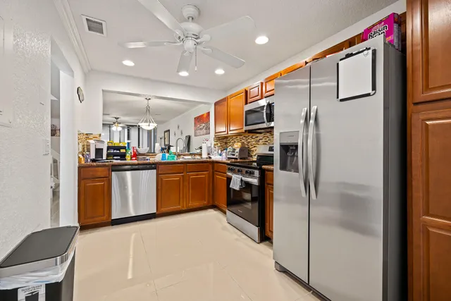 a kitchen with stainless steel appliances granite countertop a refrigerator a oven a sink dishwasher and a refrigerator with wooden floor