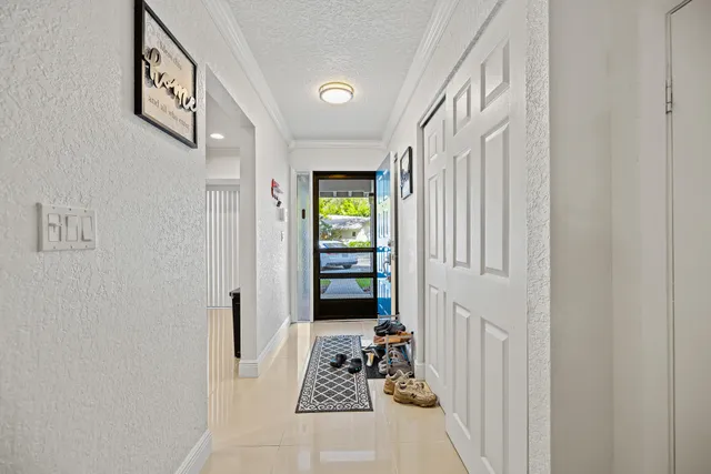 a view of a hallway with wooden floor and windows