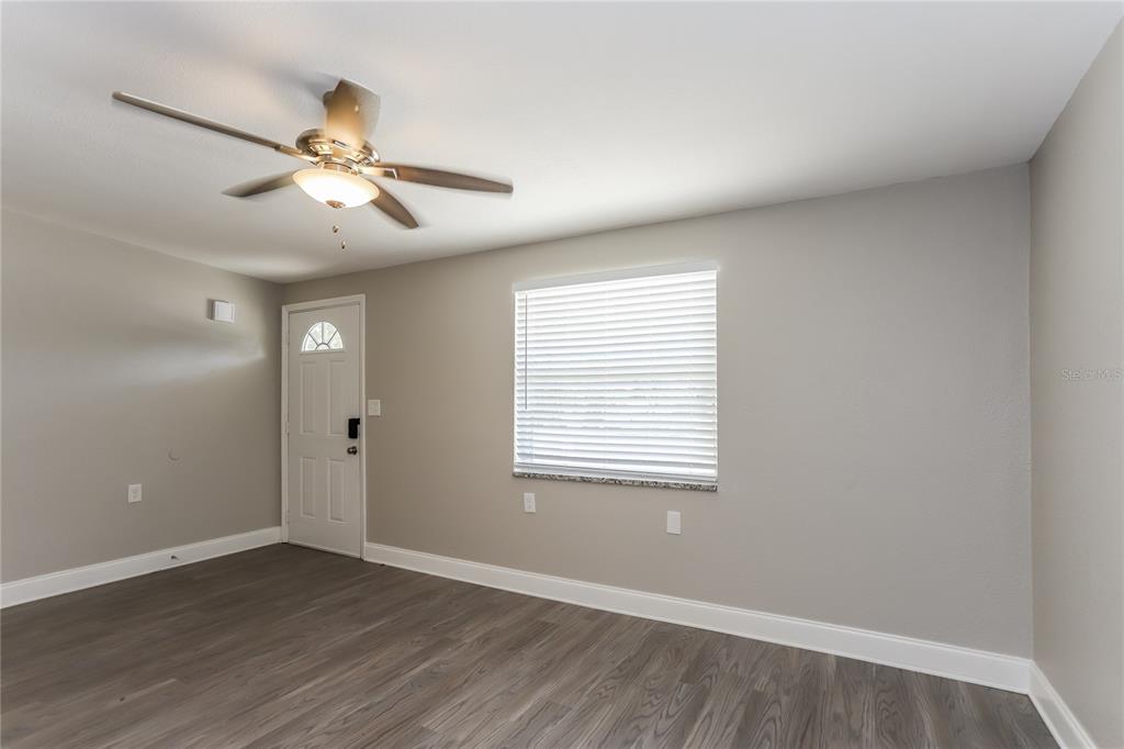1960 Cecil Street Largo, FL 33774 - Photo 2 of 16 a view of an empty room with wooden floor and a window