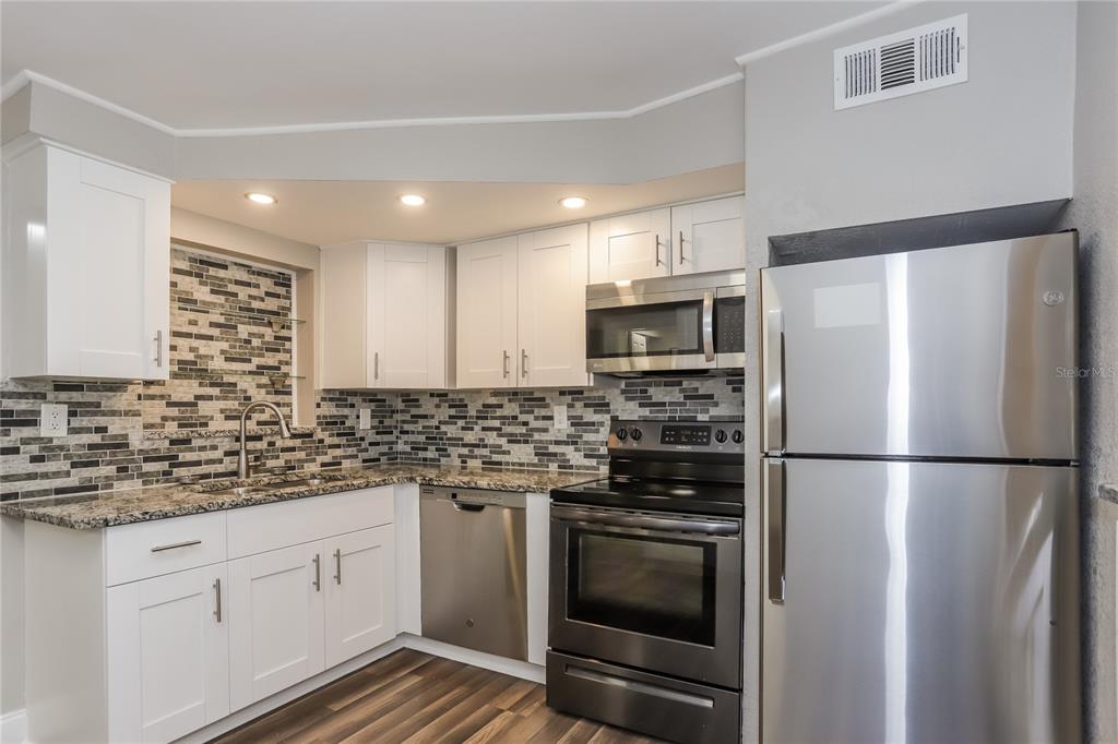 1960 Cecil Street Largo, FL 33774 - Photo 4 of 16 a kitchen with stainless steel appliances a refrigerator sink and microwave