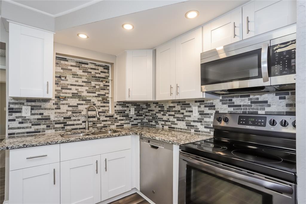 1960 Cecil Street Largo, FL 33774 - Photo 5 of 16 a kitchen with stainless steel appliances a stove microwave and cabinets