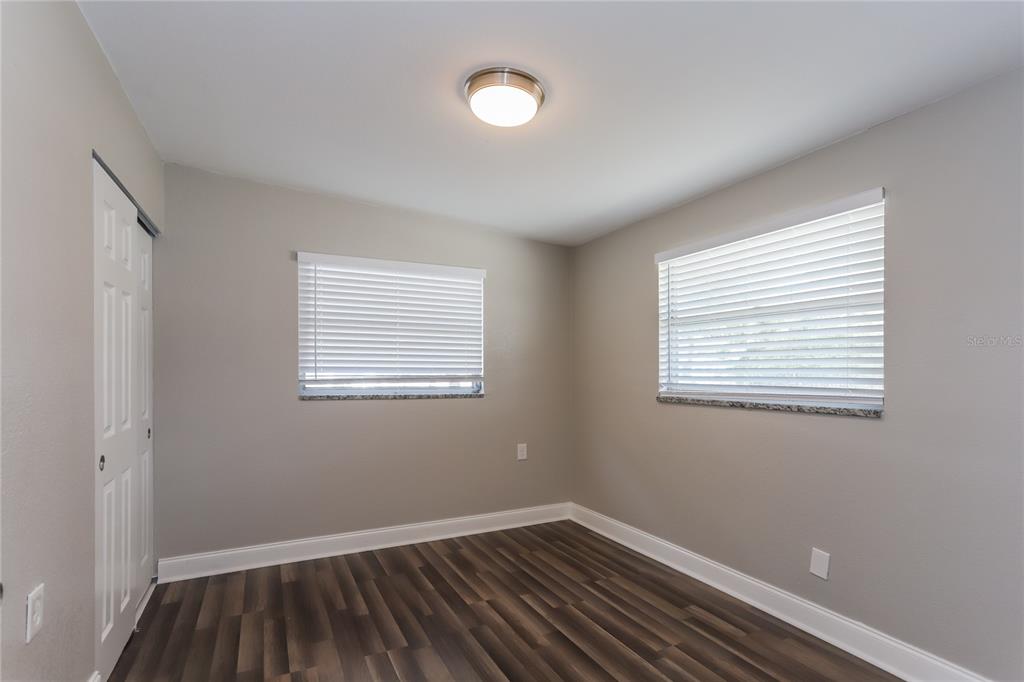 1960 Cecil Street Largo, FL 33774 - Photo 10 of 16 a view of an empty room with wooden floor and a window
