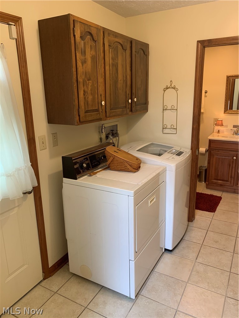 303 Orchard View Road Northeast Lancaster, OH 43130 - Photo 26 of 50 Washroom with cabinets, washing machine and dryer, light tile floors, and hookup for a washing machine