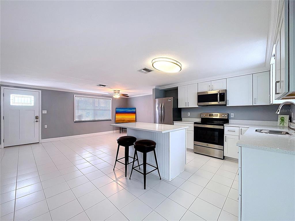 13429 Lisa Drive Hudson, FL 34667 - Photo 4 of 26 a kitchen with stainless steel appliances kitchen island granite countertop a sink and cabinets