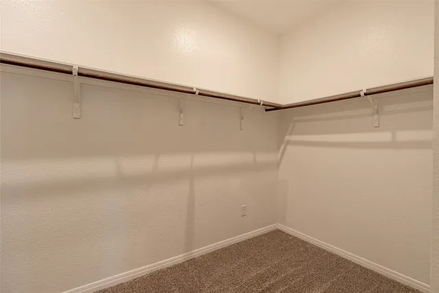 a view of an empty room with window and closet area
