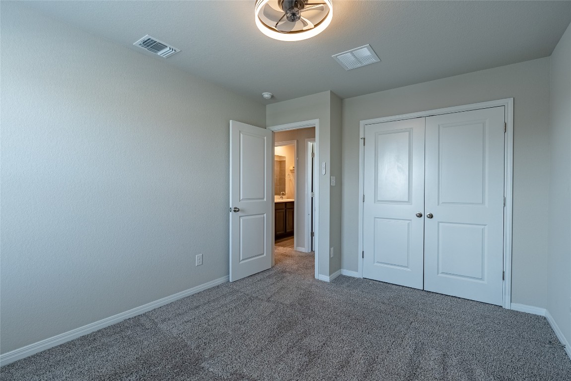 107 Cona Way Hutto, TX 78634 - Photo 21 of 26 Unfurnished bedroom featuring carpet and a closet