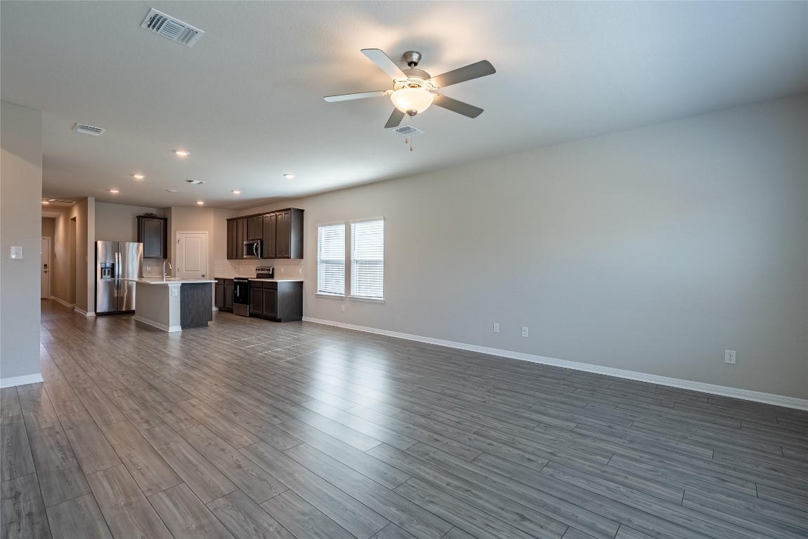 107 Cona Way Hutto, TX 78634 - Photo 6 of 26 Unfurnished living room featuring dark wood finished floors, recessed lighting, and a ceiling fan