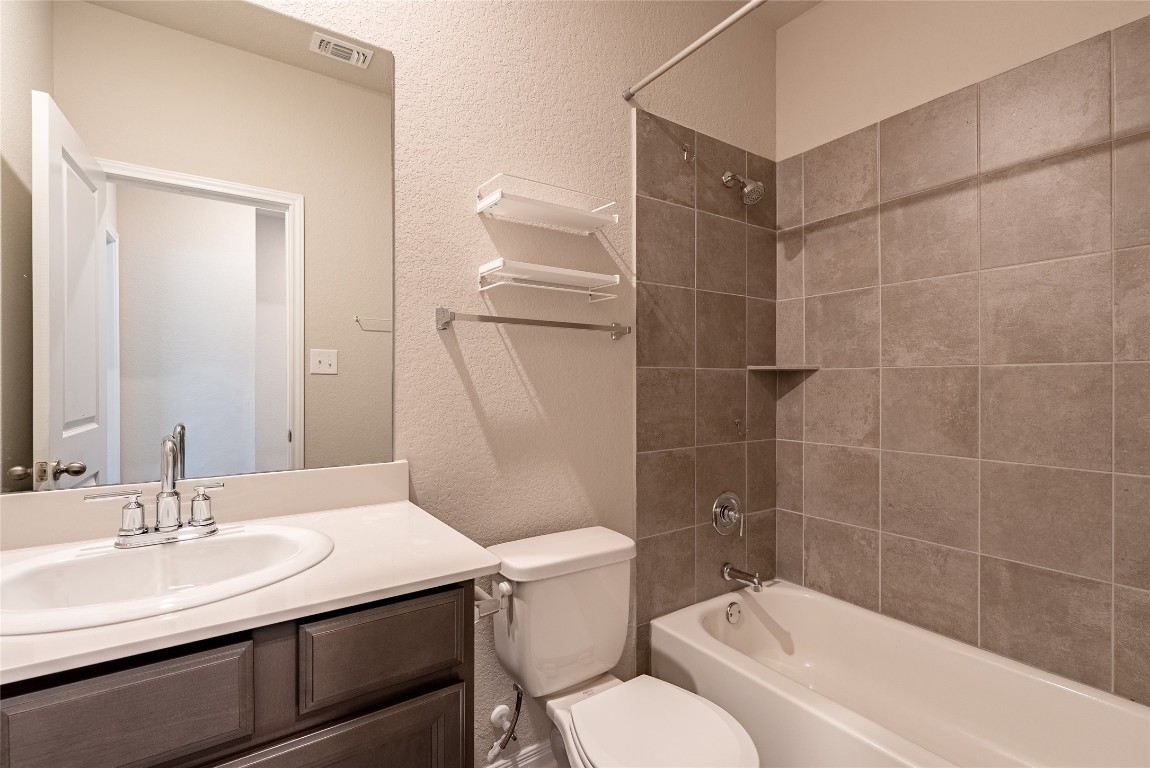 107 Cona Way Hutto, TX 78634 - Photo 9 of 26 Bathroom featuring a textured wall, shower / bathtub combination, and vanity