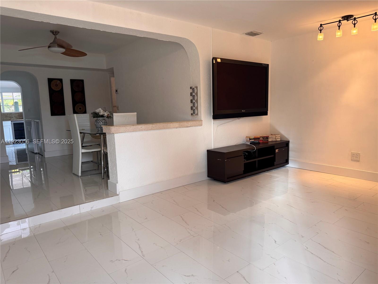 1773 Northeast 50th Street Pompano Beach, FL 33064 - Photo 5 of 7 a living room with furniture and a flat screen tv