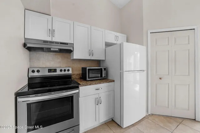 a kitchen with cabinets stainless steel appliances and a counter space