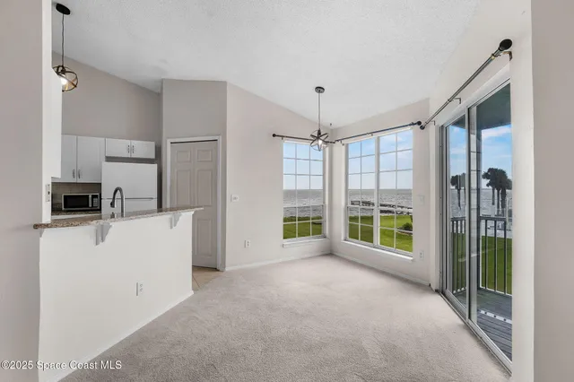 a view of a kitchen with refrigerator stove and wooden floor