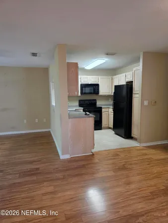 a view of an empty room with a floor to ceiling window and an outdoor view