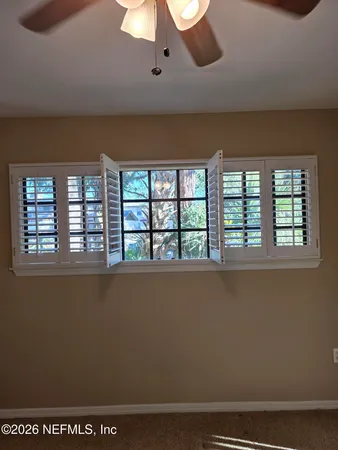a view of an empty room with a chandelier fan