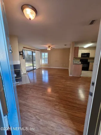 an empty room with wooden floor and fireplace