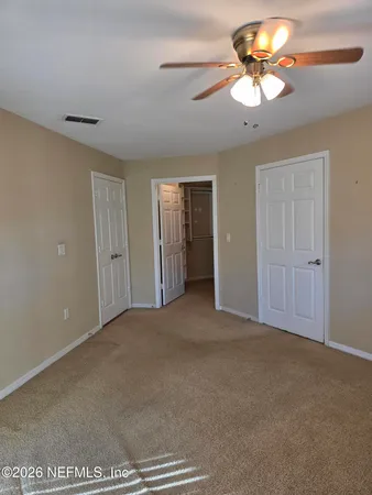 a view of walk in closet with empty racks