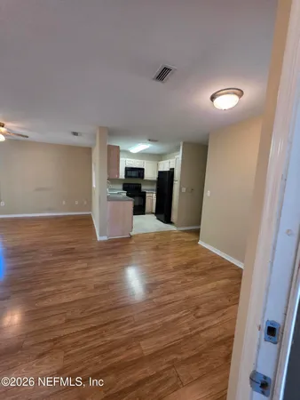 a view of empty room with wooden floor
