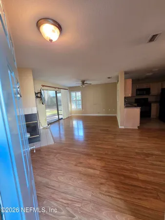 an empty room with wooden floor and windows