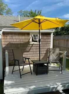 a view of a roof deck with table and chairs under an umbrella