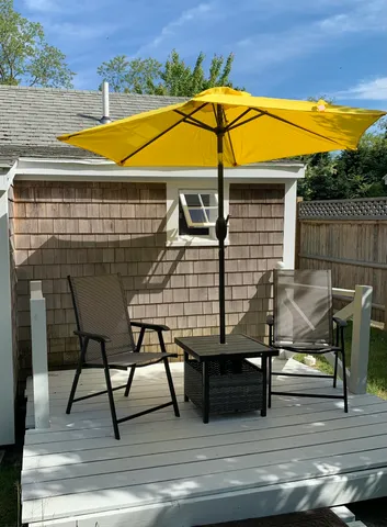 a view of a roof deck with table and chairs under an umbrella