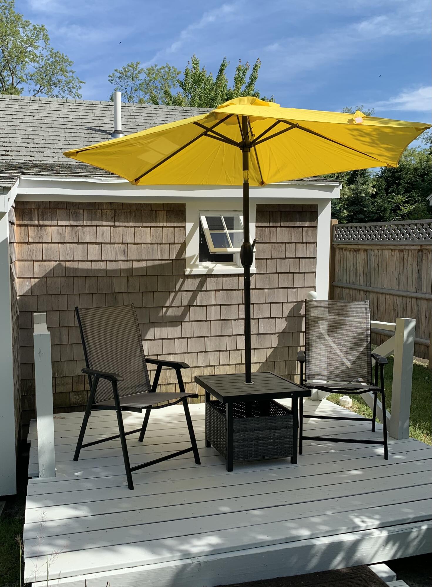 1061 State Highway, Unit 4 Eastham, MA 02642 - Photo 16 of 27 a view of a roof deck with table and chairs under an umbrella