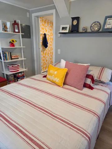 a bedroom with bed and painting on the wall