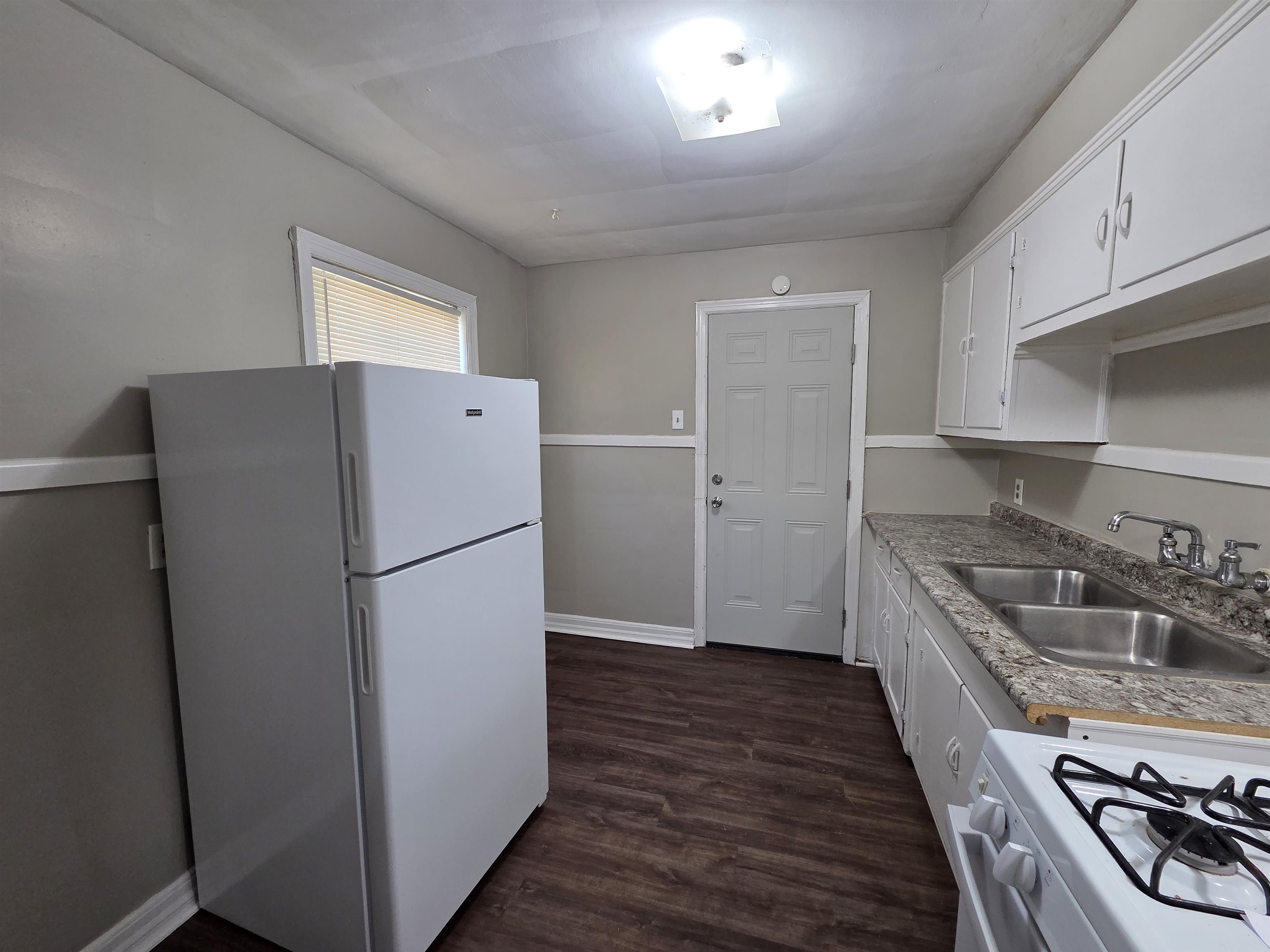 802 North Dunlap Street Memphis, TN 38107 - Photo 12 of 18 Kitchen with white appliances, dark wood-style flooring, white cabinetry, and light countertops