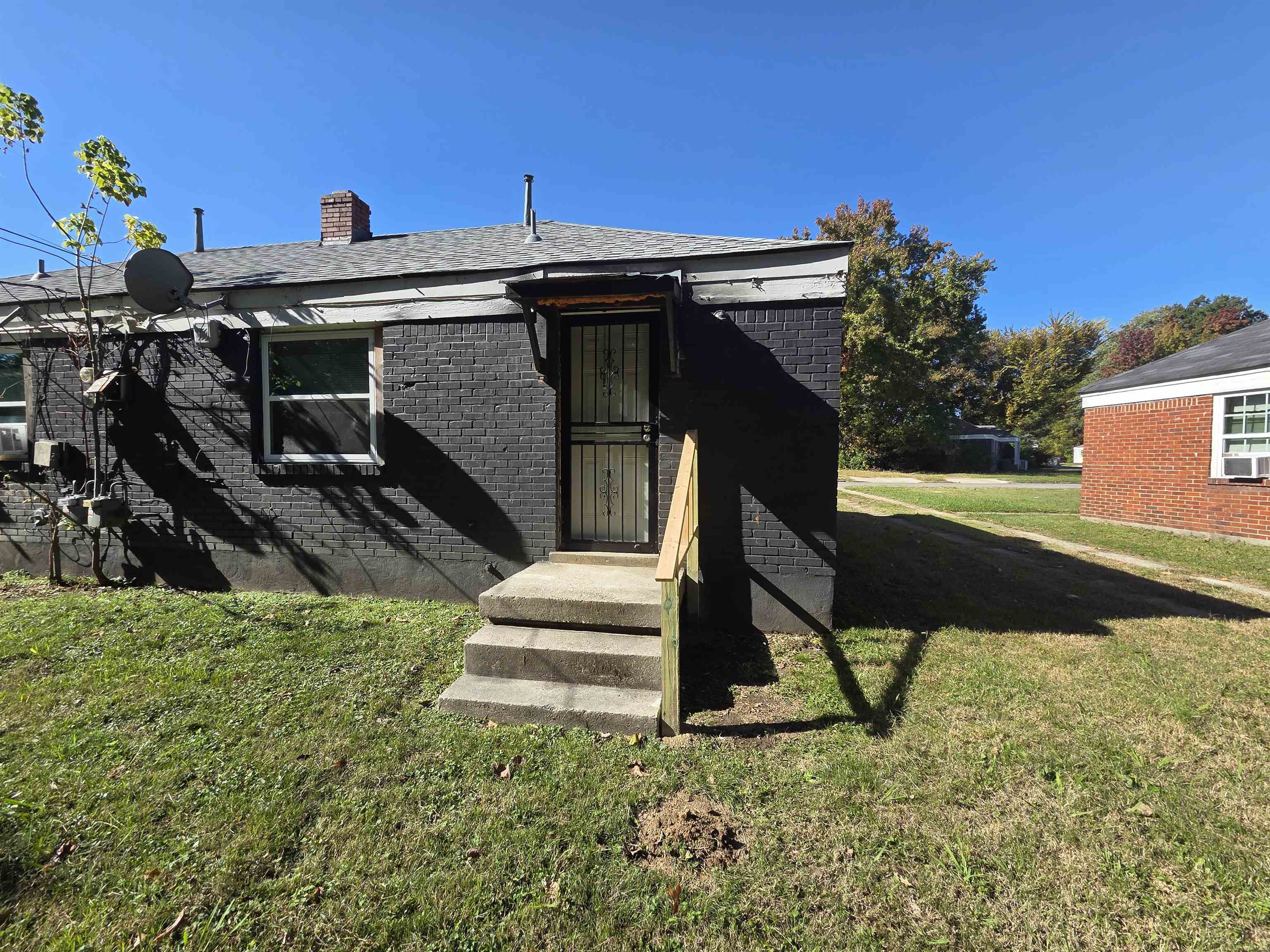 802 North Dunlap Street Memphis, TN 38107 - Photo 18 of 18 View of front of property featuring a front yard, a chimney, and brick siding