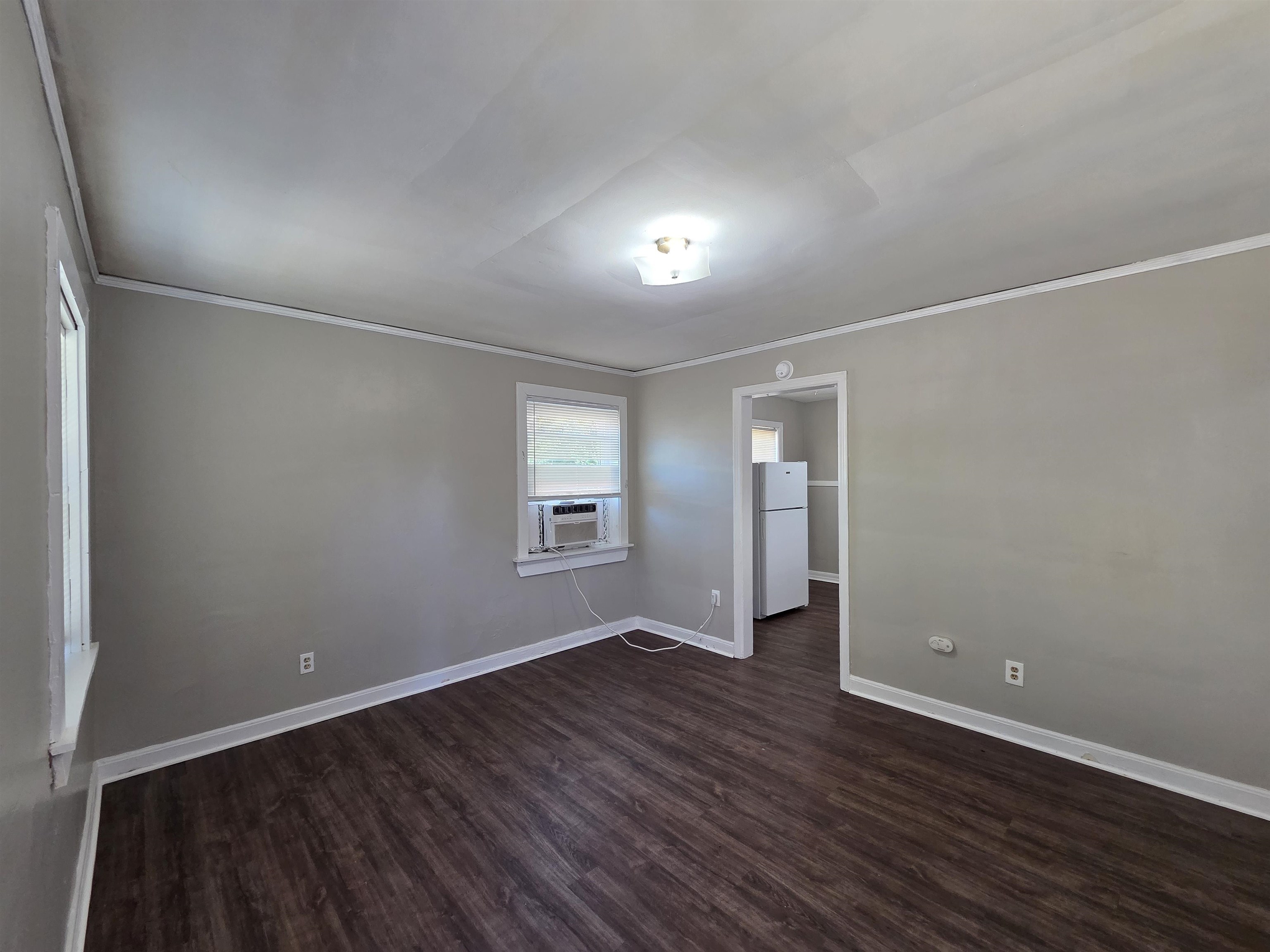 802 North Dunlap Street Memphis, TN 38107 - Photo 2 of 18 an empty room with wooden floor and windows