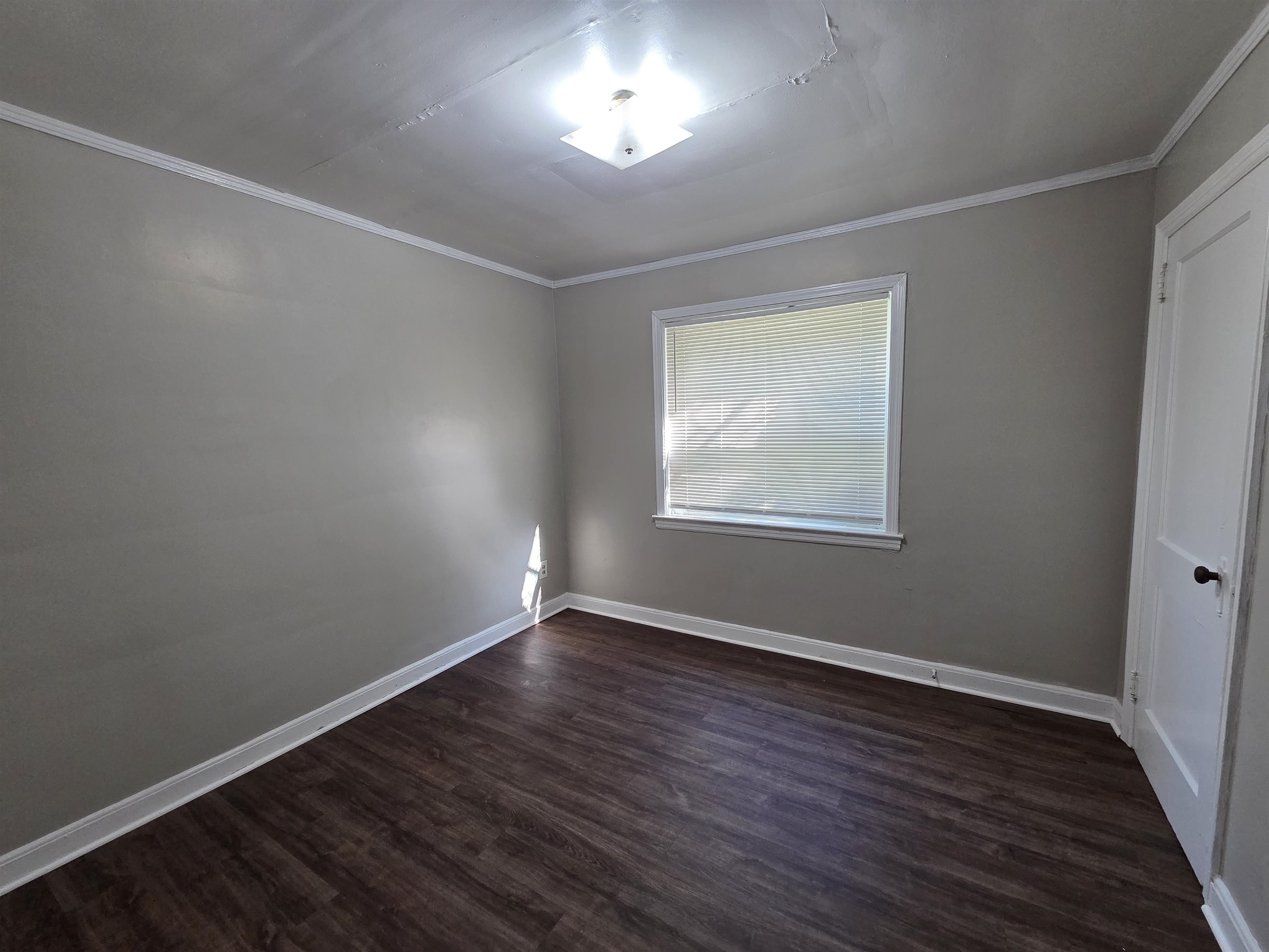 802 North Dunlap Street Memphis, TN 38107 - Photo 6 of 18 Spare room featuring dark wood-style flooring and crown molding