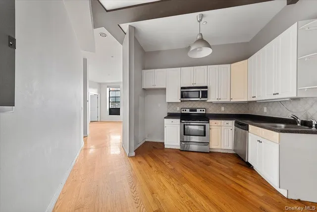 a kitchen with granite countertop a refrigerator and a stove top oven