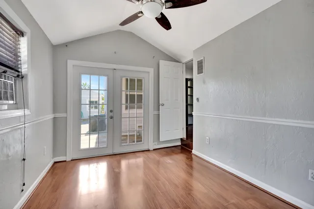 a view of an empty room with window and wooden floor