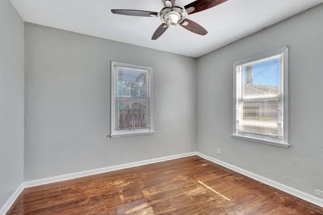 a view of an empty room with wooden floor