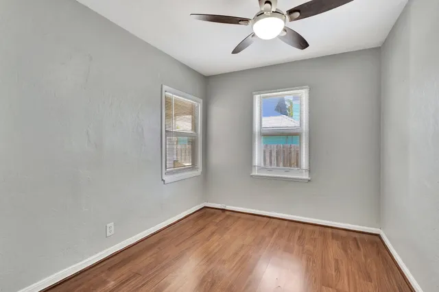 a view of an empty room with wooden floor