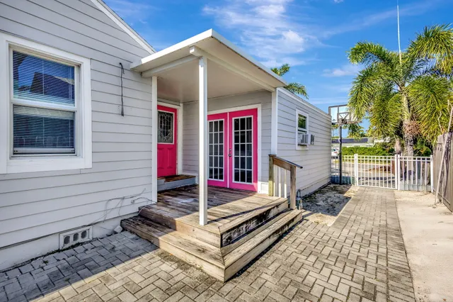 a view of a house with a small yard and wooden fence