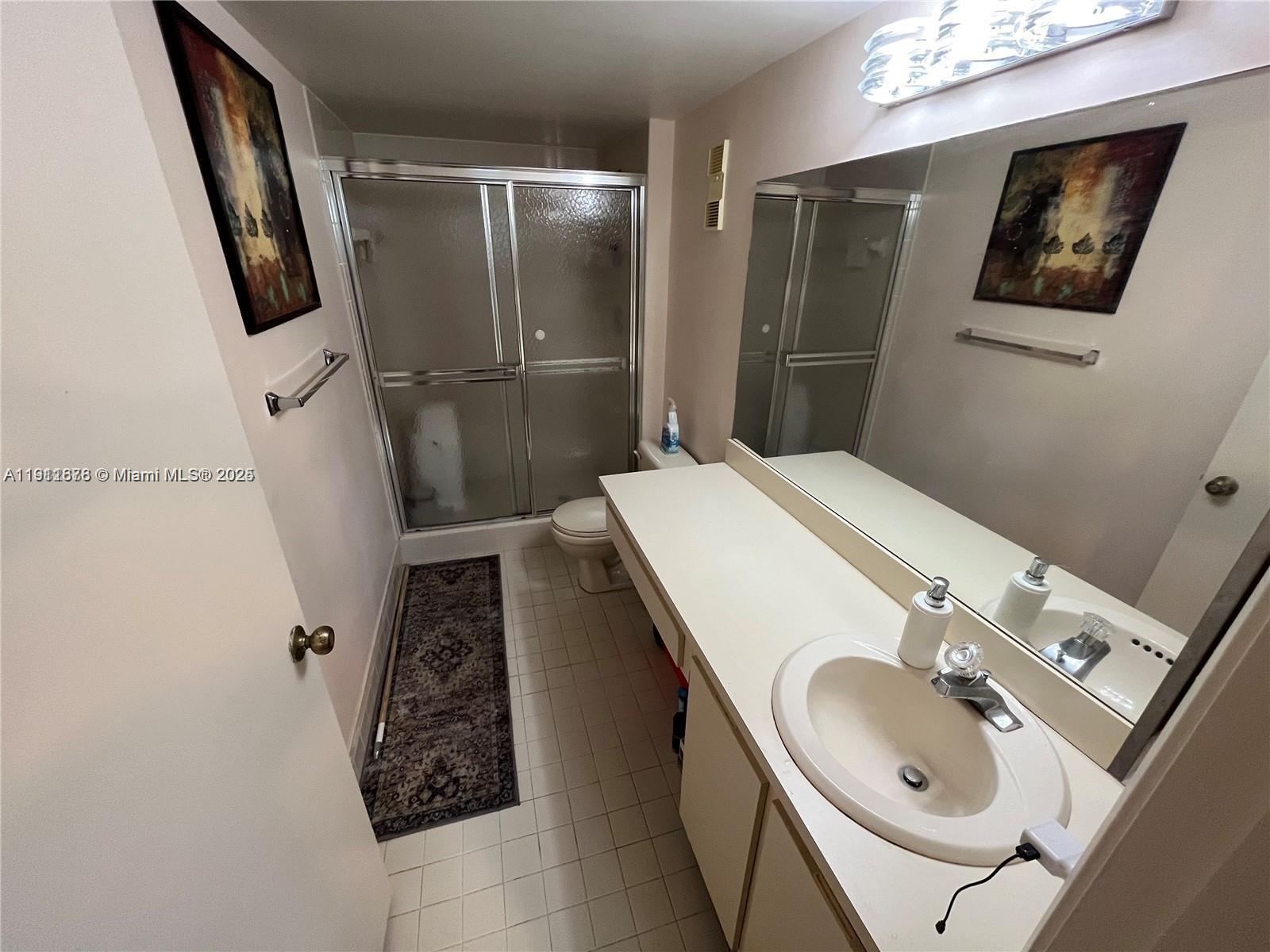 2230 North Cypress Bend Drive, Unit 309 Pompano Beach, FL 33069 - Photo 12 of 31 a bathroom with a sink a mirror and shower