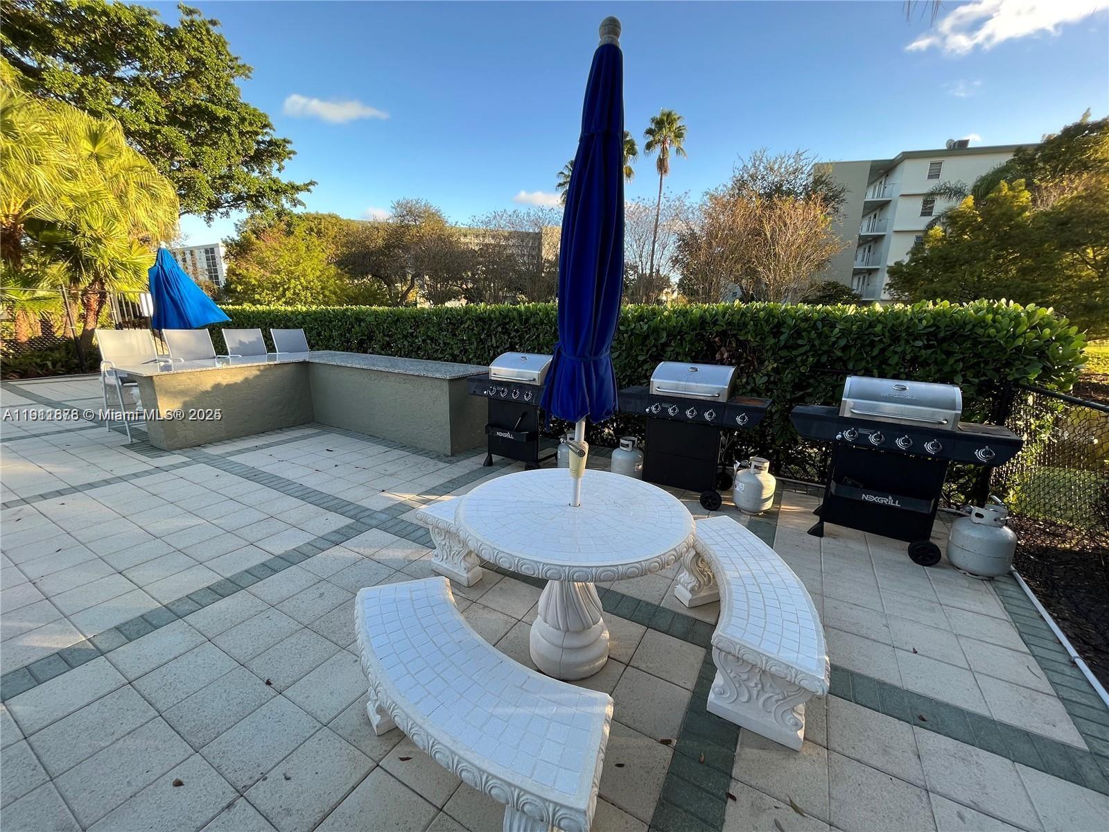 2230 North Cypress Bend Drive, Unit 309 Pompano Beach, FL 33069 - Photo 23 of 31 a outdoor patio with table and chairs