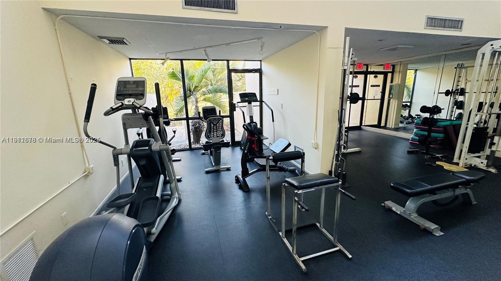2230 North Cypress Bend Drive, Unit 309 Pompano Beach, FL 33069 - Photo 28 of 31 a room with gym equipment and windows