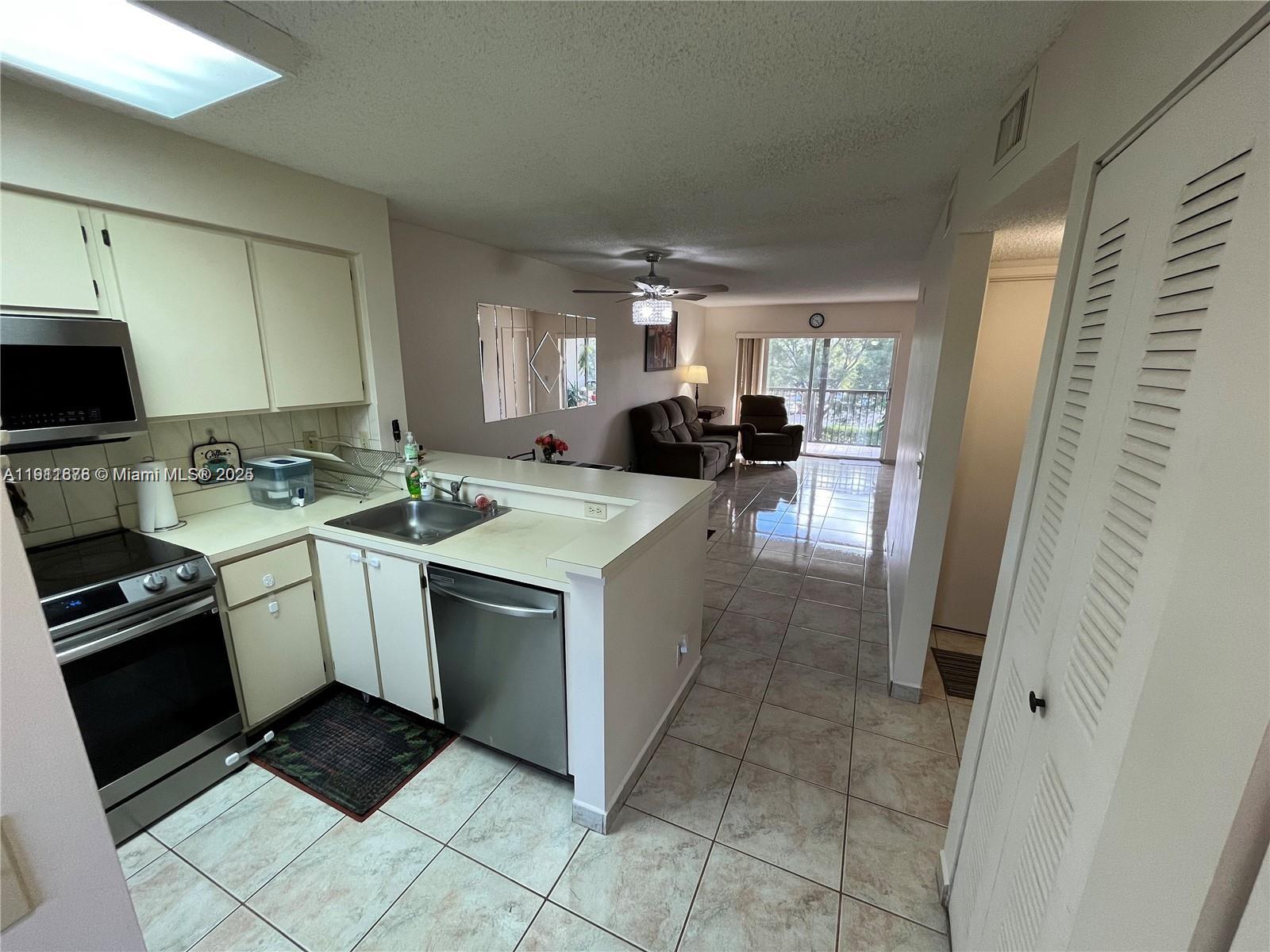 2230 North Cypress Bend Drive, Unit 309 Pompano Beach, FL 33069 - Photo 3 of 31 a kitchen with a sink stove and cabinets