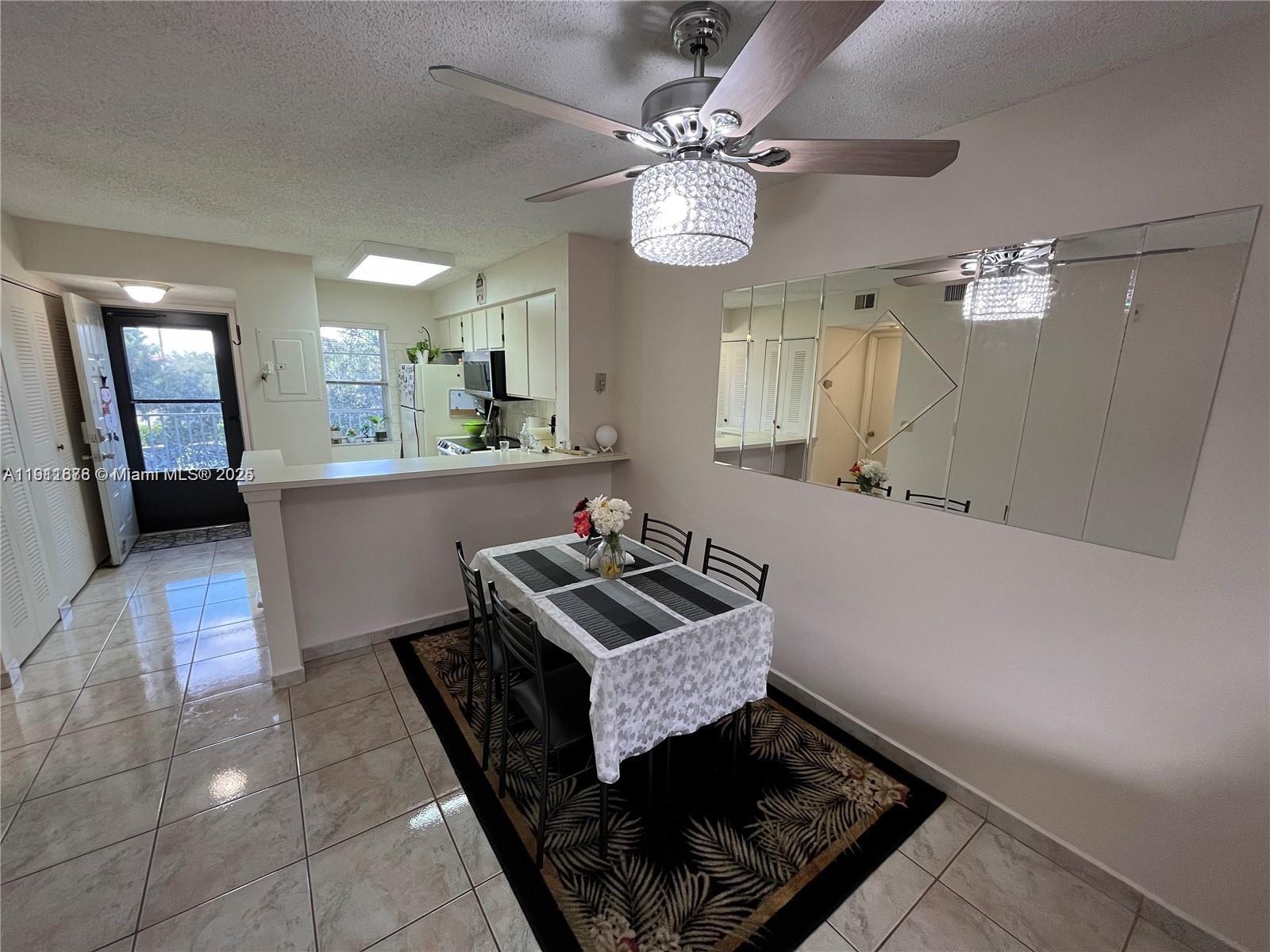 2230 North Cypress Bend Drive, Unit 309 Pompano Beach, FL 33069 - Photo 6 of 31 a living room with furniture and a chandelier