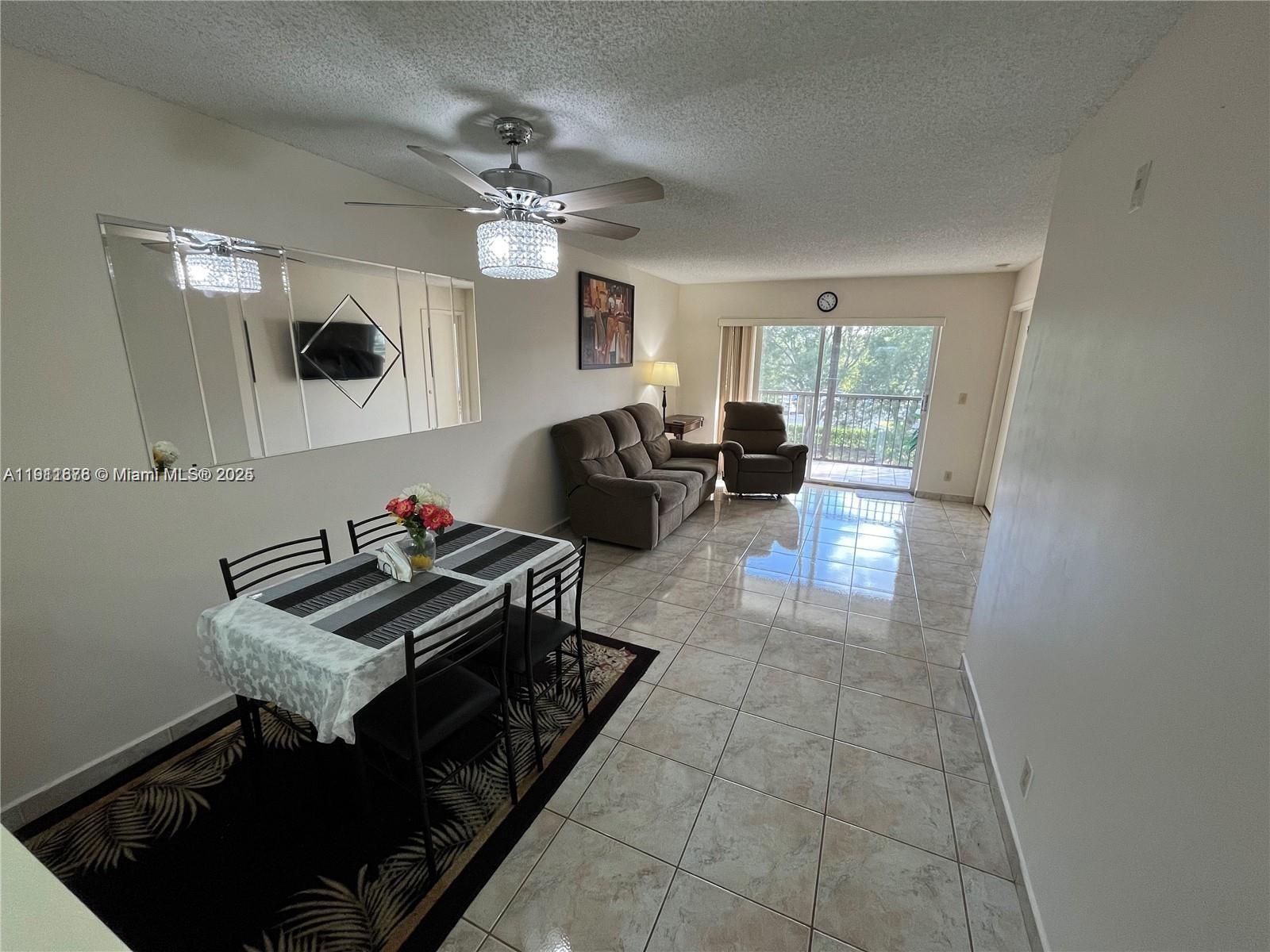 2230 North Cypress Bend Drive, Unit 309 Pompano Beach, FL 33069 - Photo 7 of 31 a living room with furniture and a chandelier