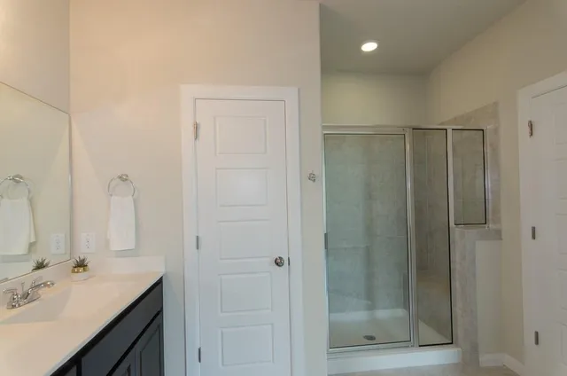 a bathroom with a shower sink vanity and mirror