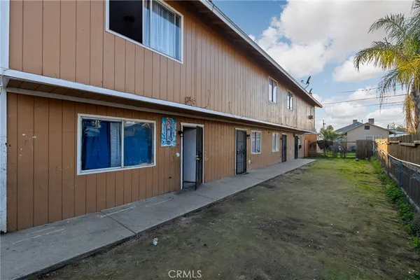 a backyard of a house with wooden fence and seating space