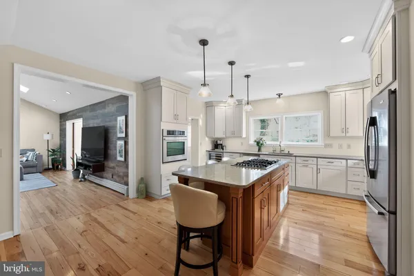 a kitchen with kitchen island granite countertop a sink appliances and cabinets