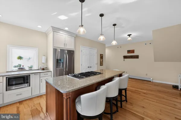 a kitchen with a kitchen island hardwood floor sink stove and refrigerator