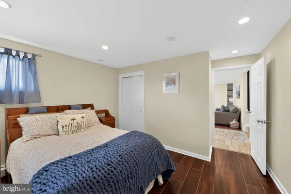a bedroom with a large bed and wooden floor